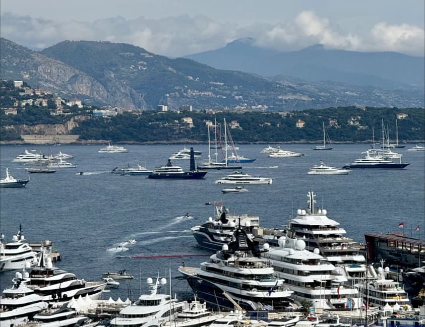 Yachts in a sheltered harbour with mountains in the distance